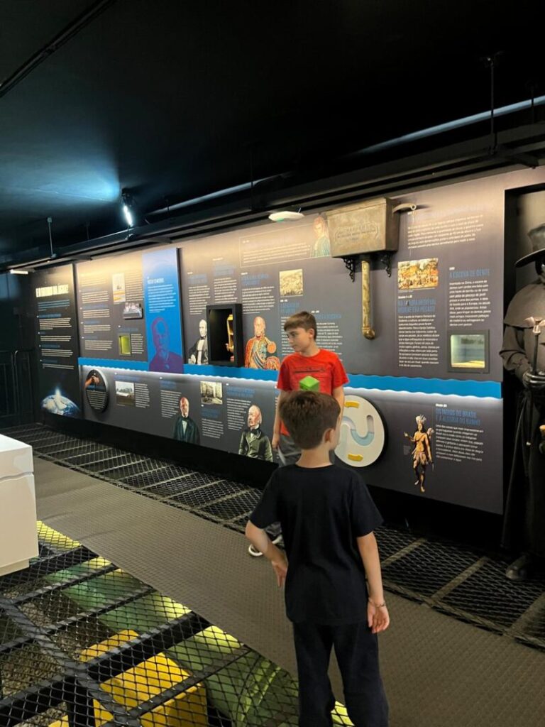dois meninos vendo paineis interativos de museu