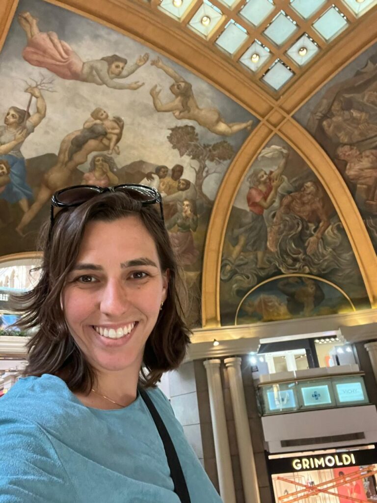 selfie de mulher mostrando teto decorado com pinturas em shopping