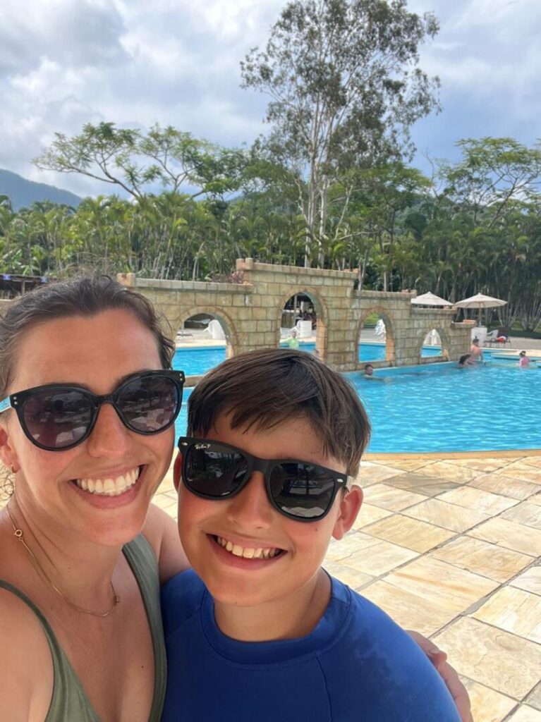 mãe e filho com piscina no fundo