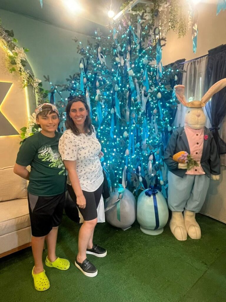 Mãe e filho em decoração de árvore de páscoa.