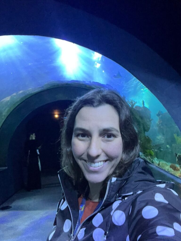 mulher em frente ao túnel do aquário