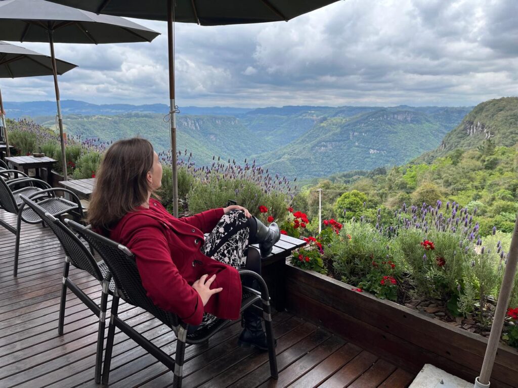 mulher sentada em deck com vista de serra