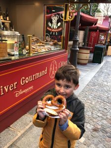 Mateus comendo um pretzel na Disney Paris