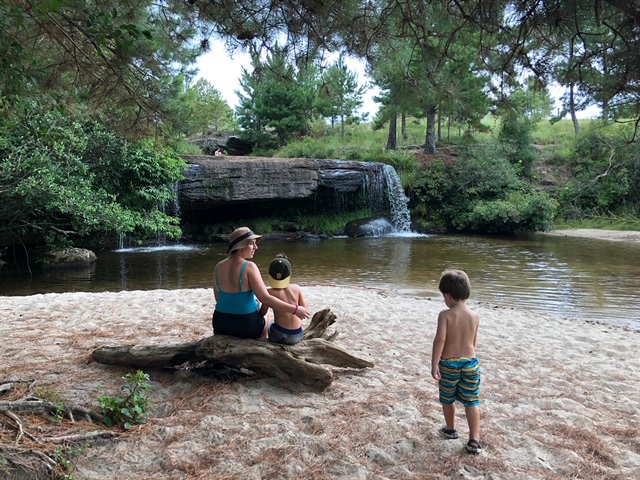 mae e filhos olhando cachoeira de costas