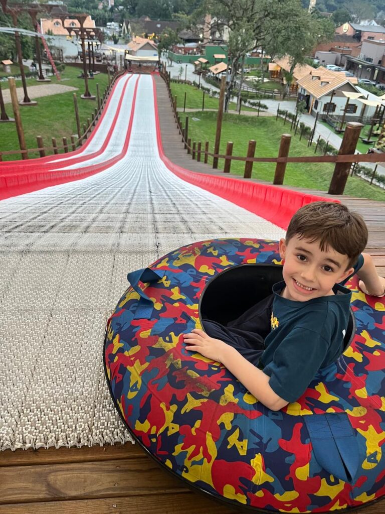 menino dentro de boia para escorregar em tubing