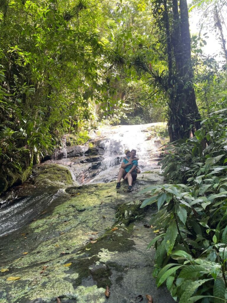 mulher e menino em uma cachoeira na mata