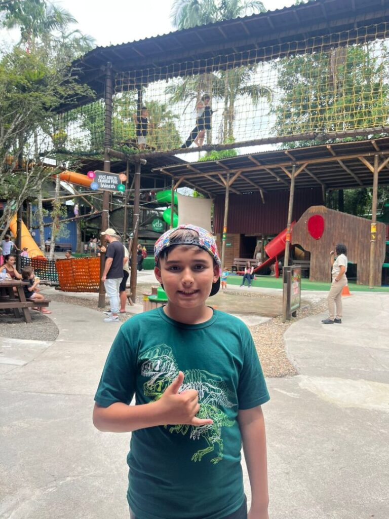 menino em frente a parque de diversões