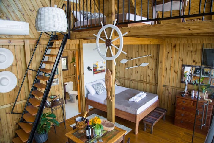 quarto em madeira e cama embaixo da escada
