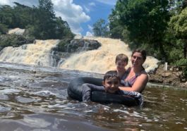 mãe e filhos no rio com cachoeira de Saltinho no fundo