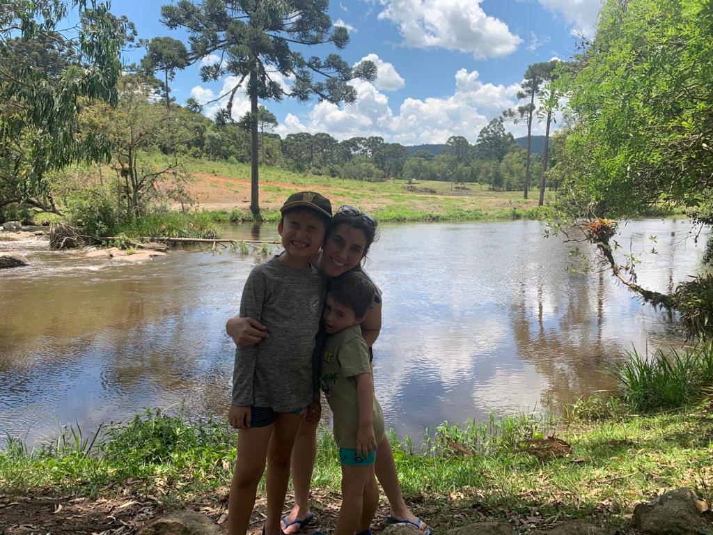 mãe e filhos com lago no fundo