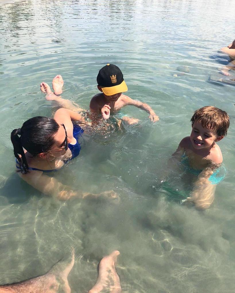 mãe e filhos em piscina natural da praia