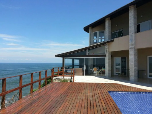 vista lateral de casa de 2 andares com piscina e deck para o mar
