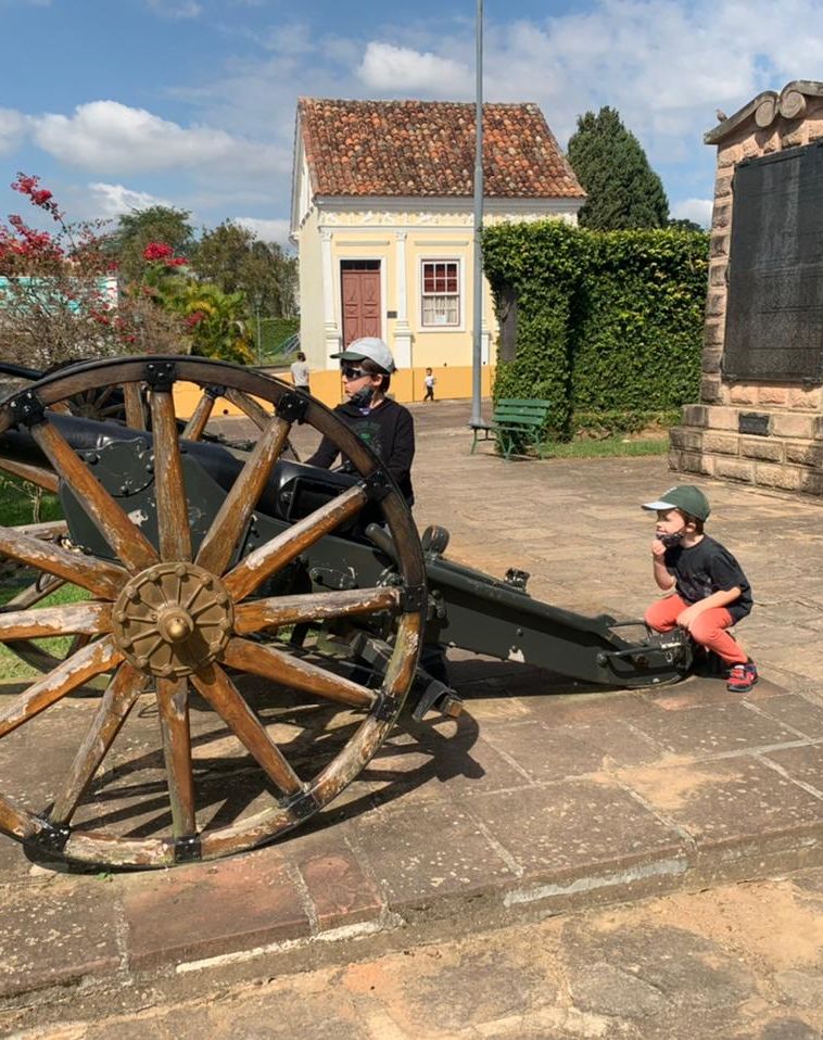 dois meninos junto a canhão em praça histórica