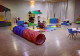salão de espaço infantil com brinquedos como túnell e piscina e bolinhas