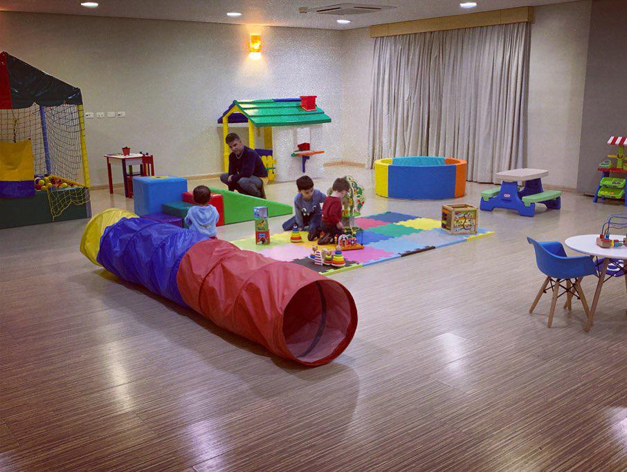 salão de espaço infantil com brinquedos como túnell e piscina e bolinhas