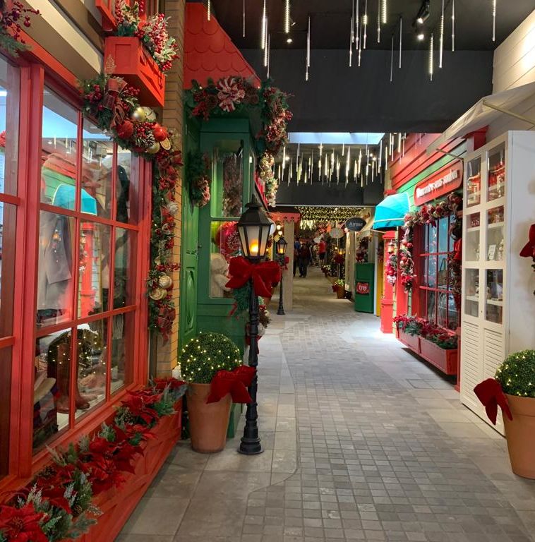 galeria comercial com decoração de natal com janela em vermelho em primeiro plano
