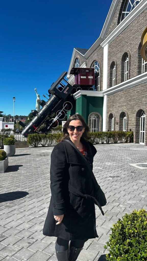 mulher em frente de fachada temática de trem caído