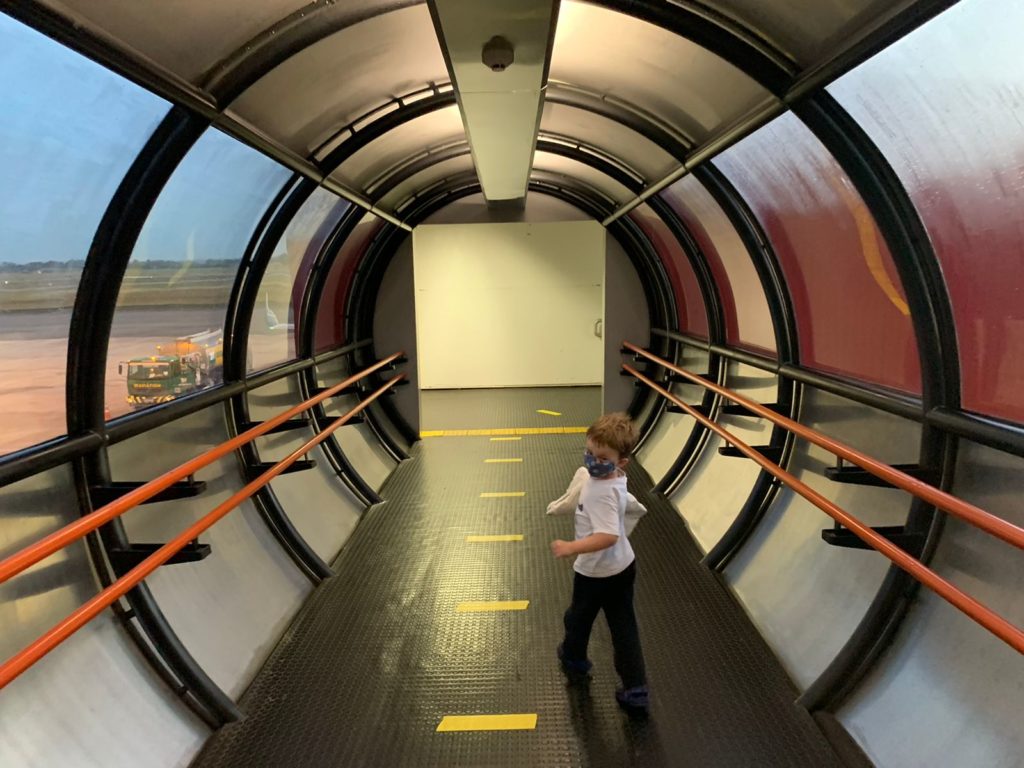 crianca no finger do aeroporto de curitiba em formato de tubo