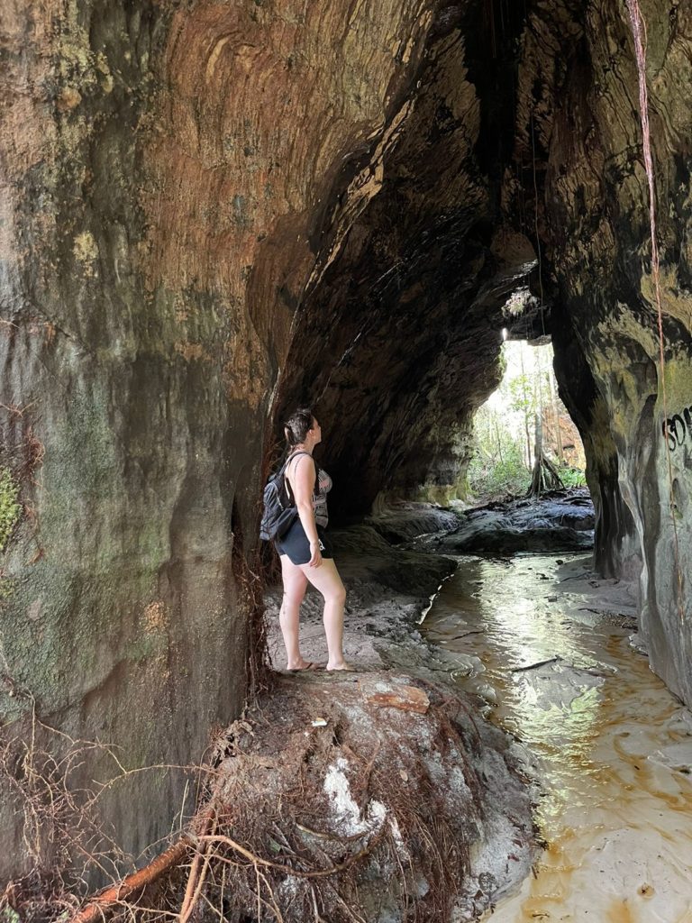 mulher de lado olhando para cima de uma caverna