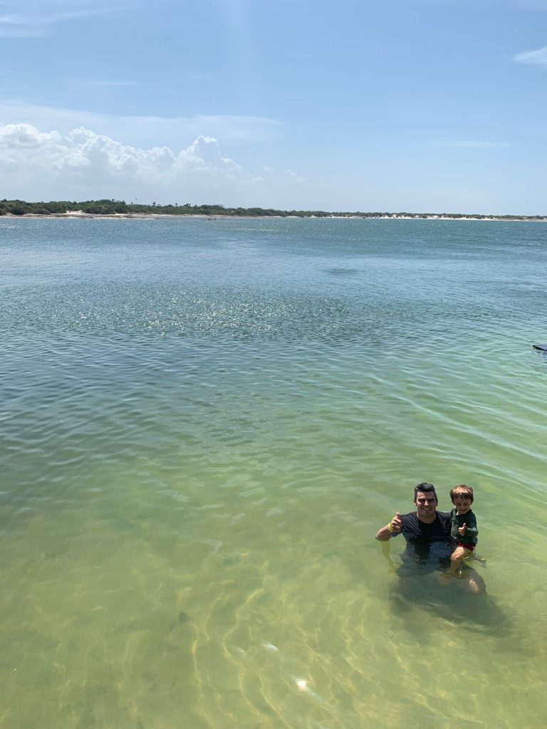 pai e criança de 4 anos em lagoa azul tranquila