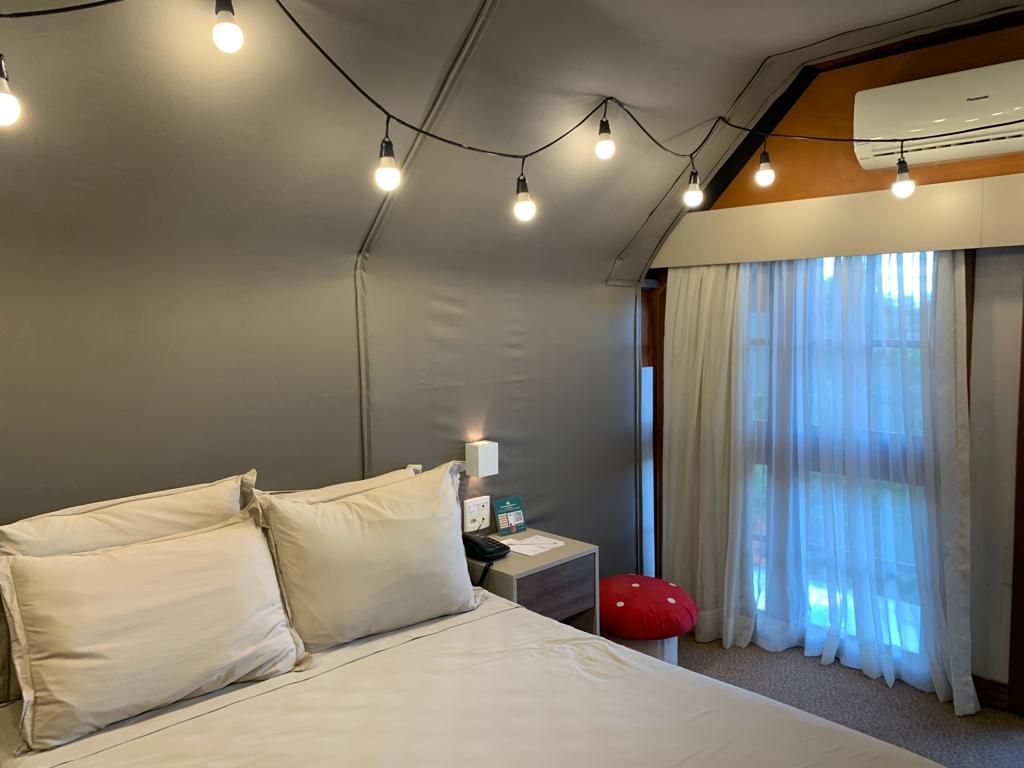 cama com quarto decorado com cabana e luzes