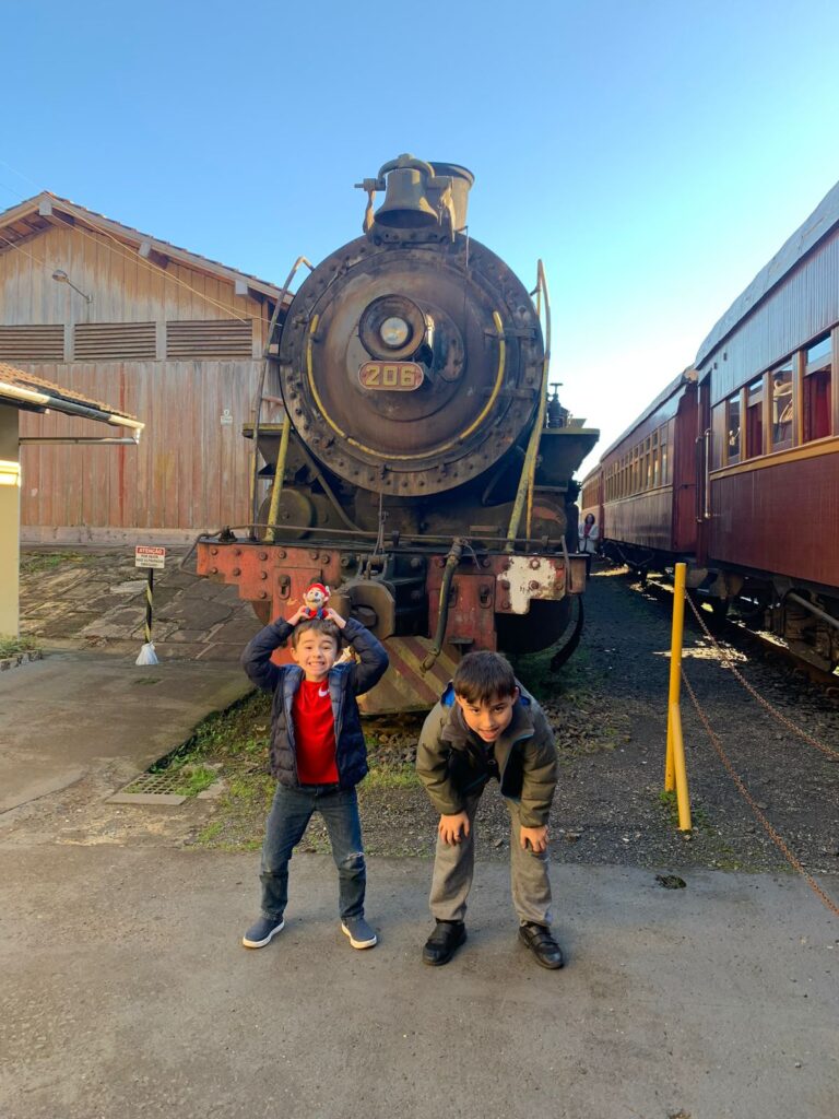 dois meninos junto com a frente de um trem