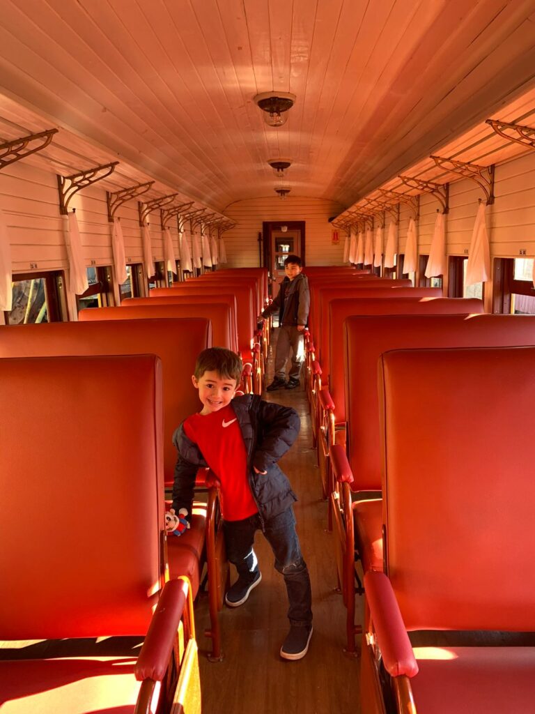vagões de trem vermelhos com duas crianças entre eles
