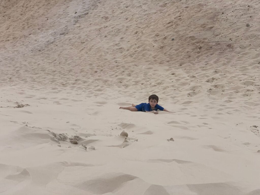menino em meio a duna de areia