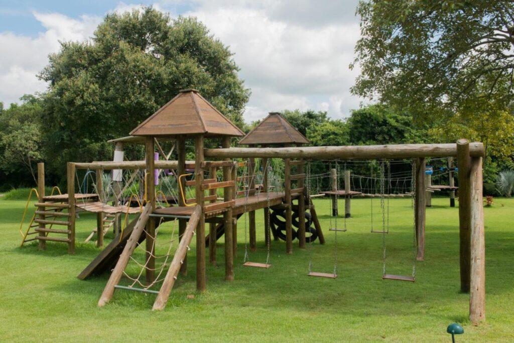 Parque infantil em madeira em gramado