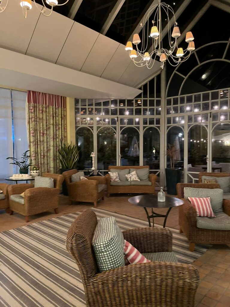 Lounge com sofás e lateral e teto em vidro