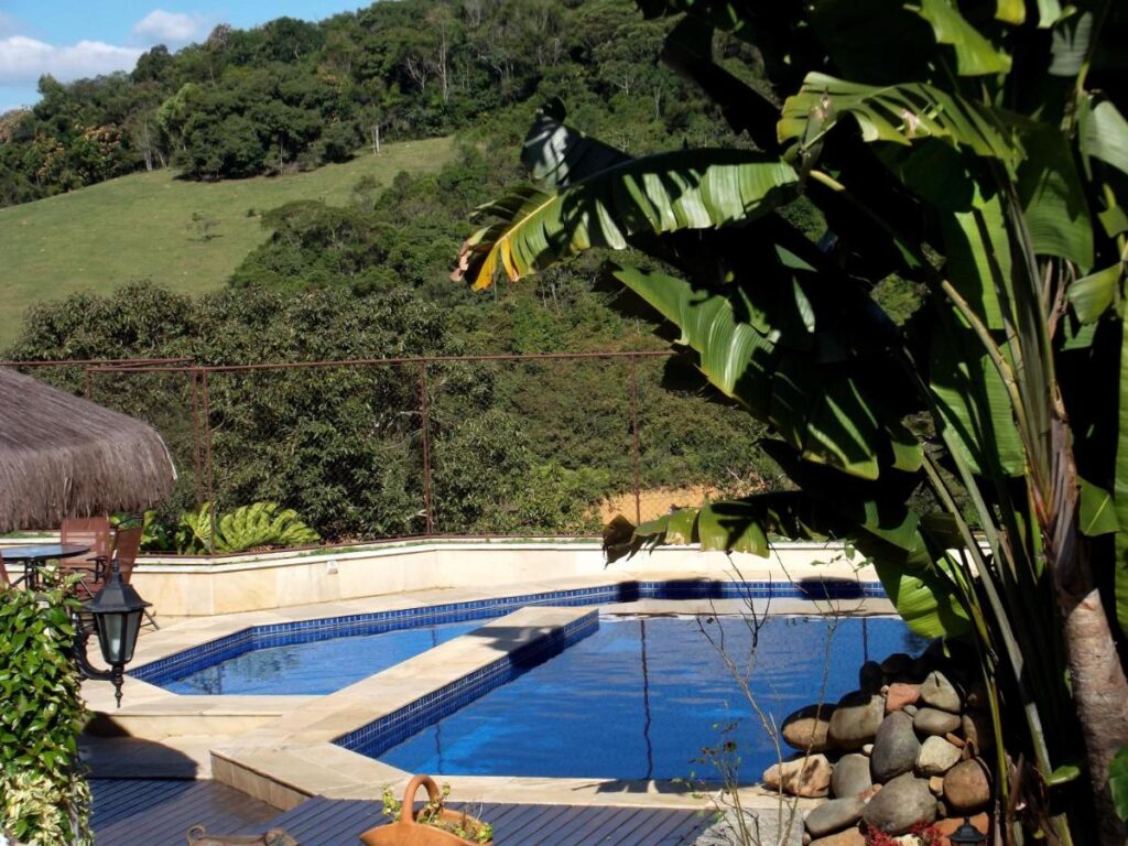 piscina com montanha com vegetação ao fundo