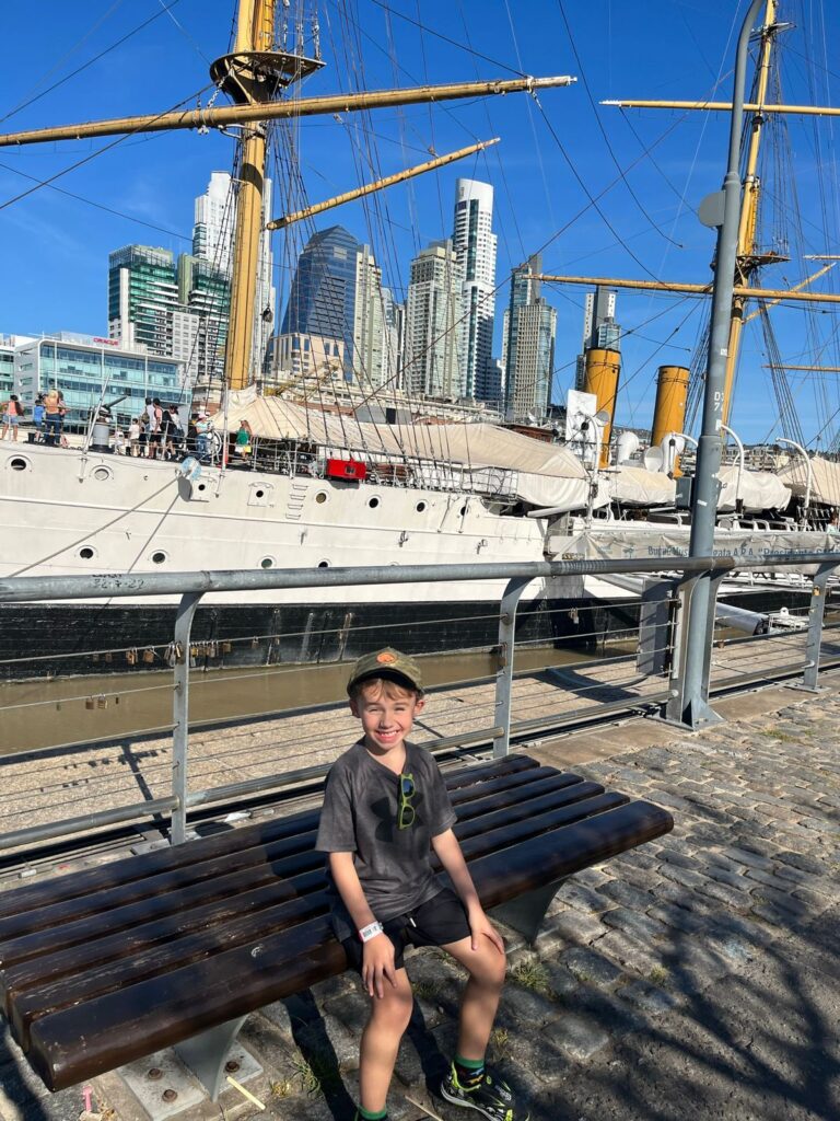 menino sentado em frente a barco