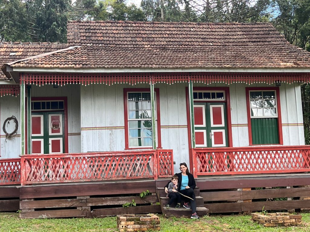 mãe e filho sentados em frente de casa histórica