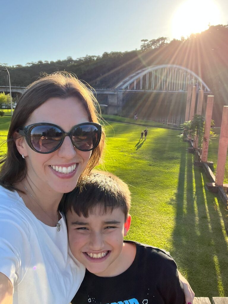 mãe e filho em selfie com ponte ao fundo