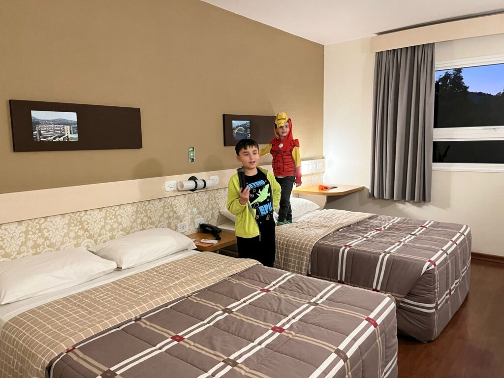 meninos entre camas de quarto de hotel