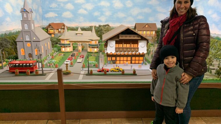 mãe e filho pequeno em frente a a maquetes com miniaturas de pontos turísticos da cidade de gramado