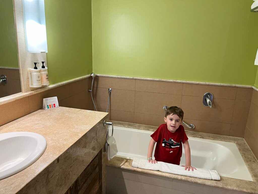 menino dentro de banheira de hotel no banheiro
