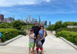 pai, mãe e dois meninos em parque com skyline de chicago no fundo