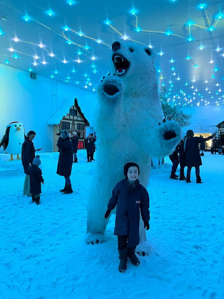 menino em frente a escultura de urso polar