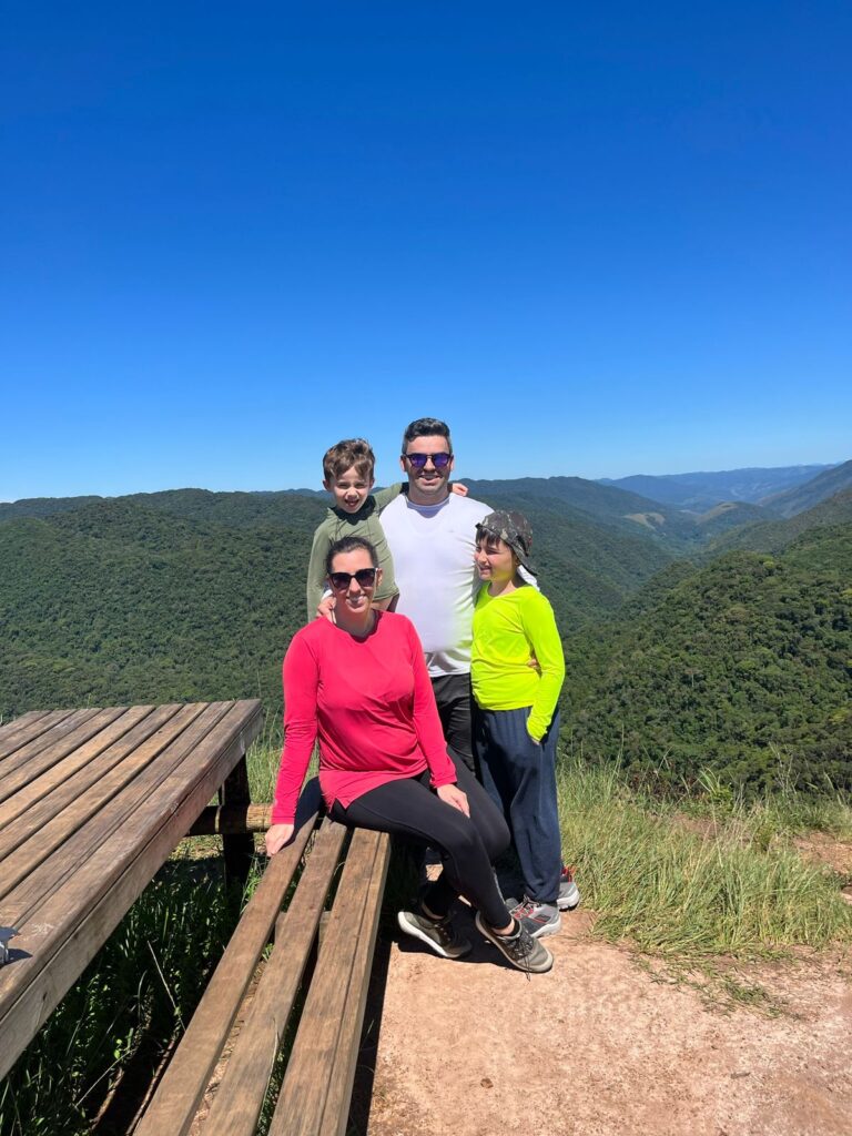 família junta de pai, mãe e dois meninos em mirante com montanhas