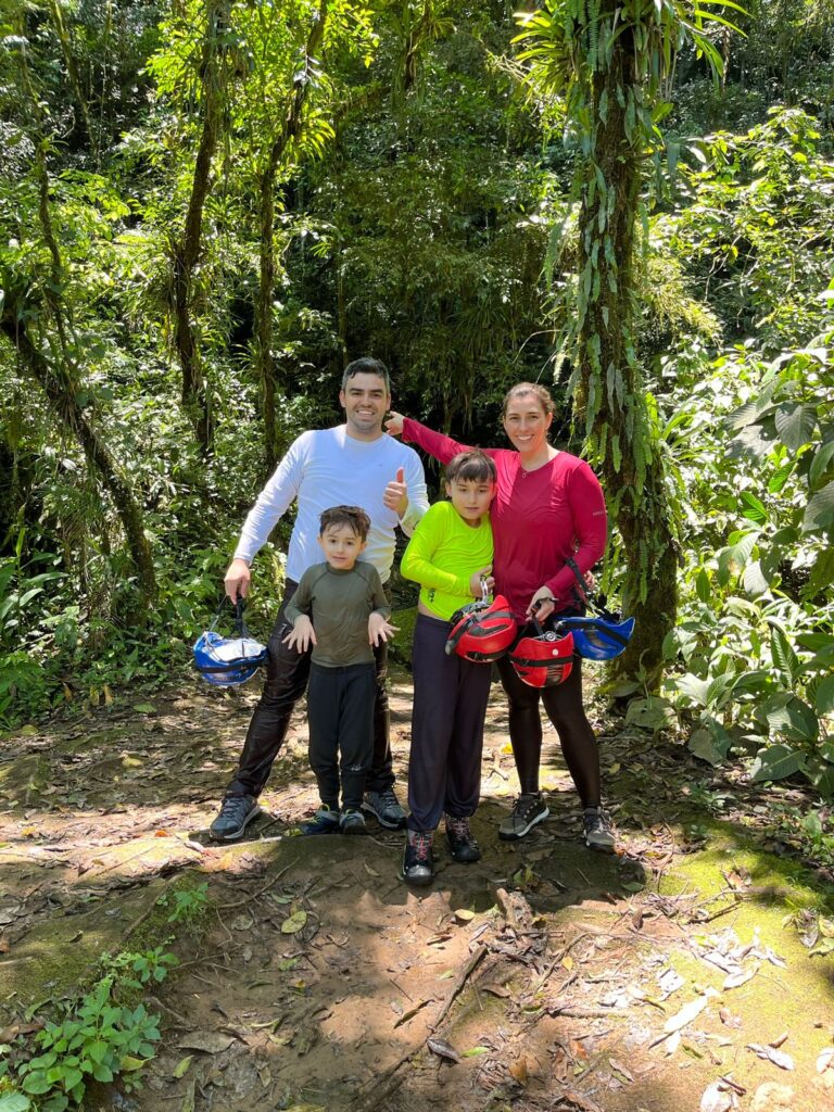 familia de mãe, pai e 2 meninos molhados em meio a árvores