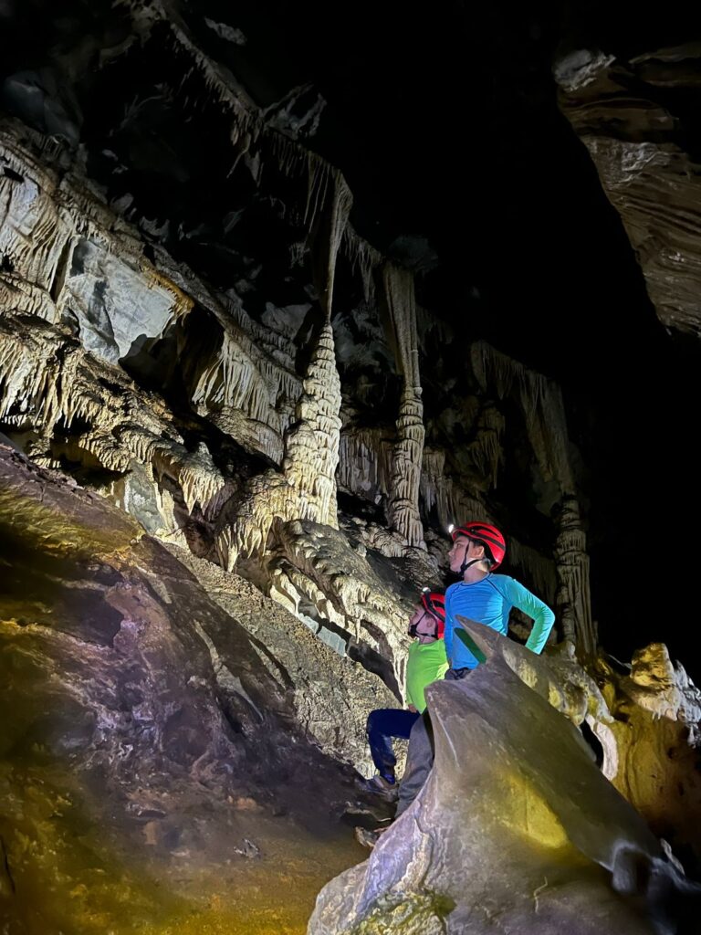 dois meninos fazendo pose de lado dentro de cavernas com estalagmites e estalactites