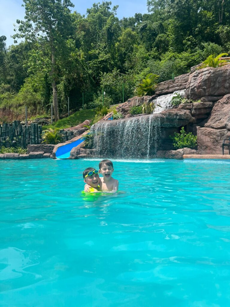 dois meninos abraçados dentro de uma piscina