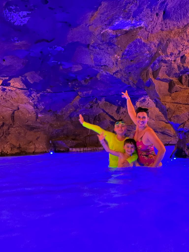 mãe e dois meninos dentro de piscina subterrânea