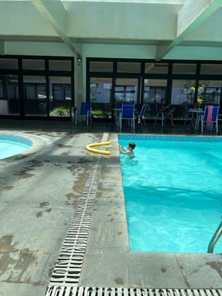 menino dentro de piscina de hotel coberta