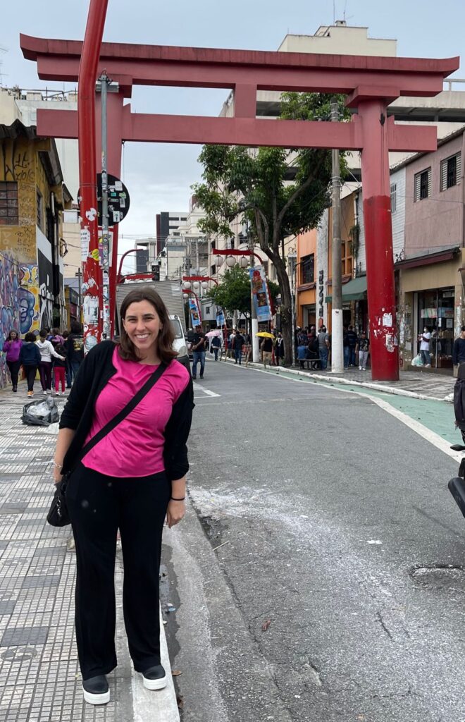 mulher em frente a rua com monumento de tori japonês