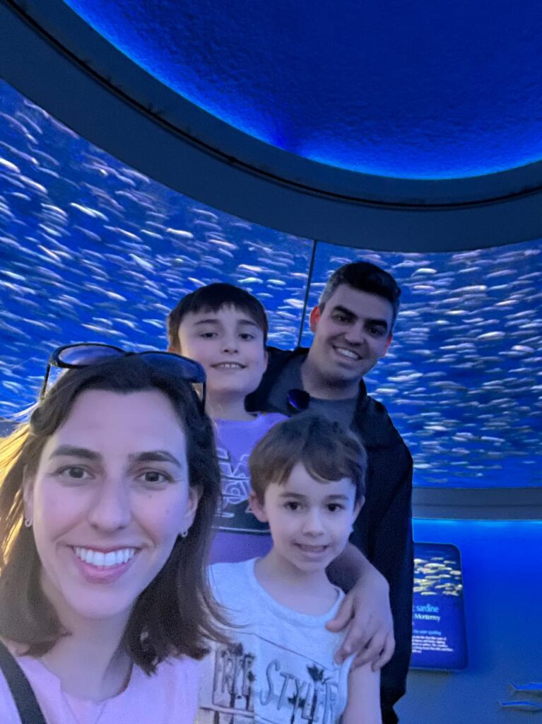 familia com aquário de muitas sardinhas ao fundo