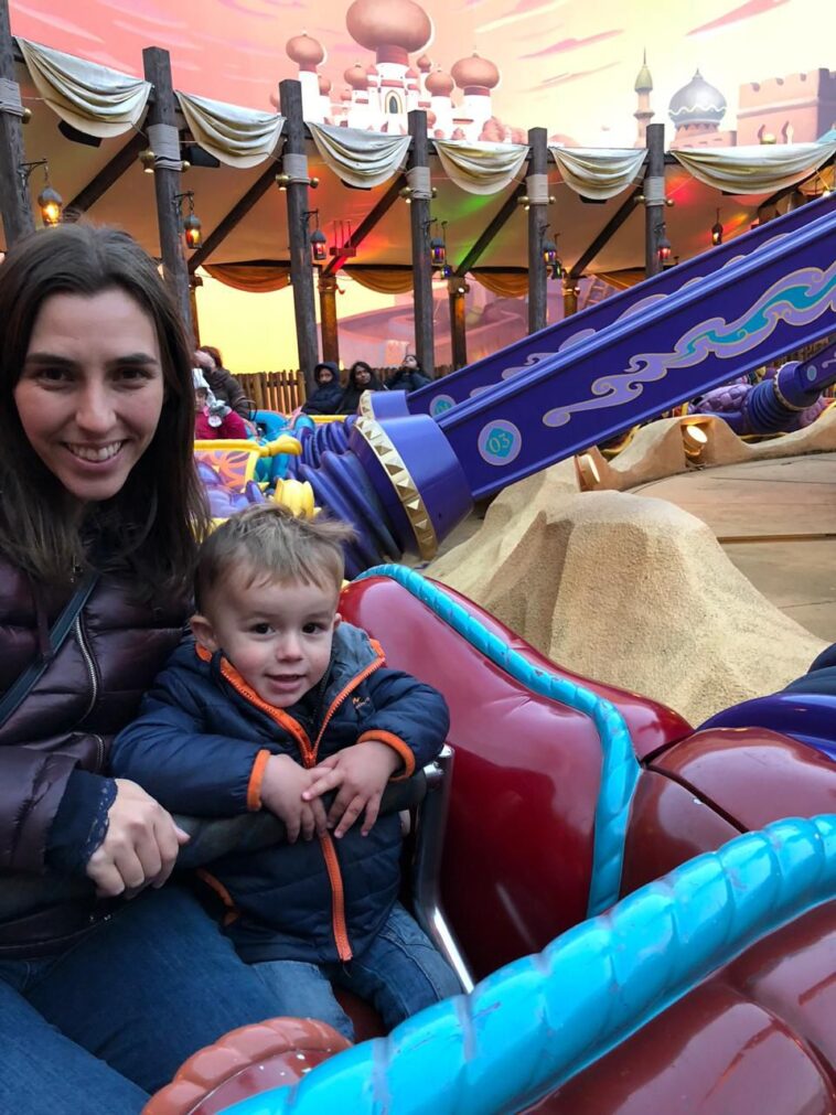 mulher e bebê sentados em atração de parque de diversões