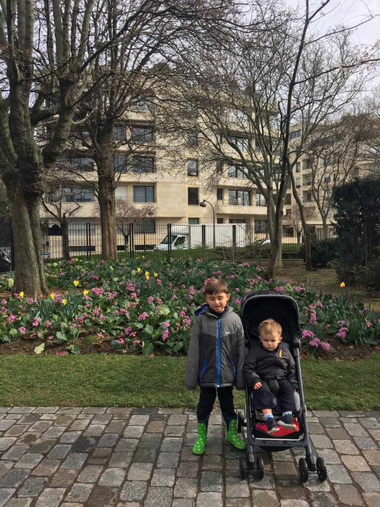 meninos e bebê em frente a jardim de parque