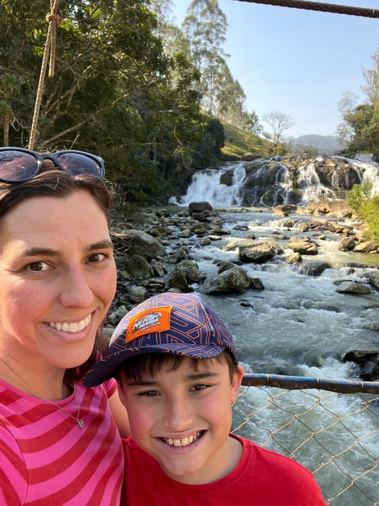 mãe e menino com cachoeira ao fundo